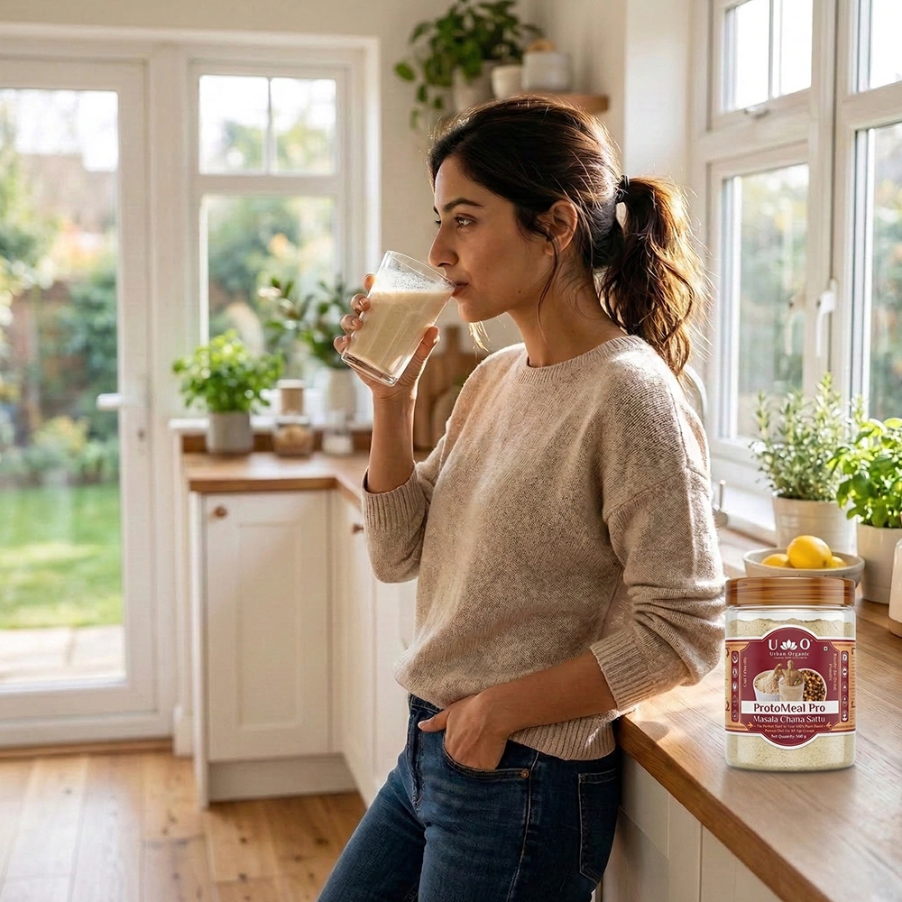 Woman enjoying a healthy glass of Urban Organic Masala Chana Sattu in a modern kitchen